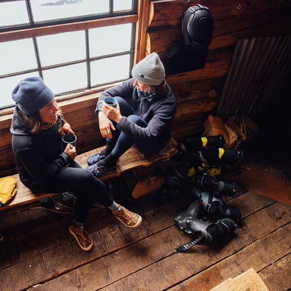 Sipping coffee next to a window in the Oboz and Skida Whakatā Puffy.