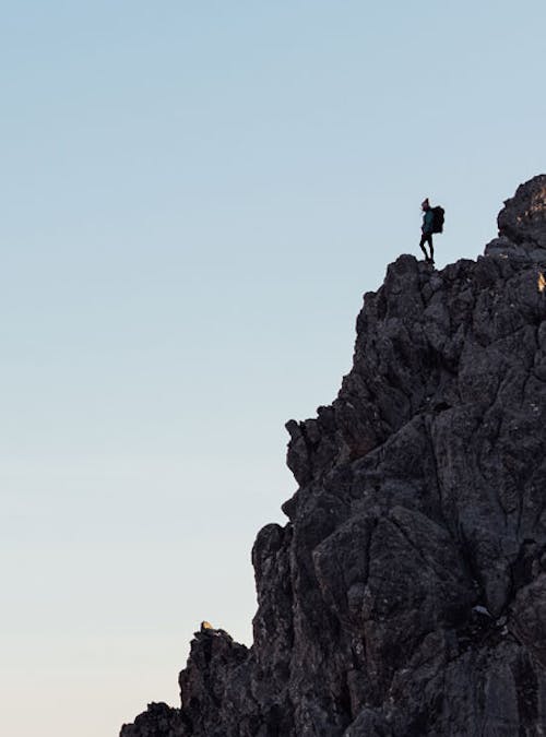 A woman admires the view atop a high rocky ledge wearing Oboz hiking boots