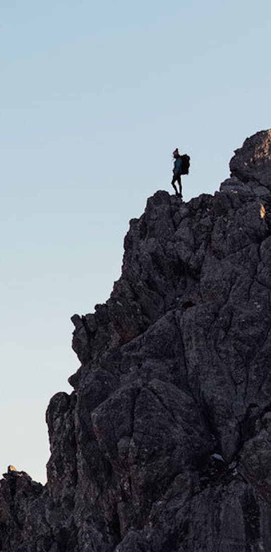 Hiker enjoying a view from a rocky mountain outcrop.