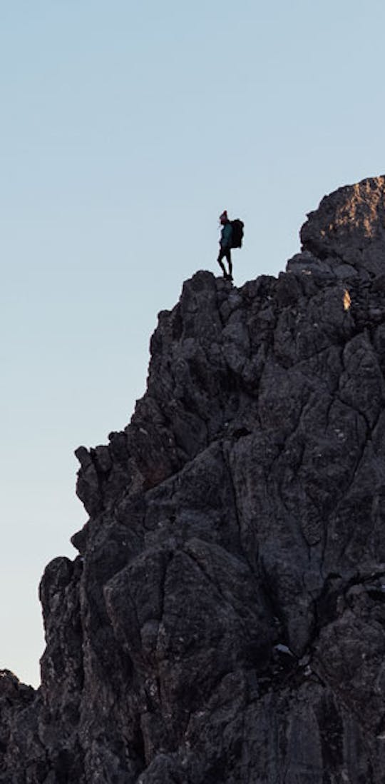 Woman on top of a mountain wearing Oboz hiking boots.