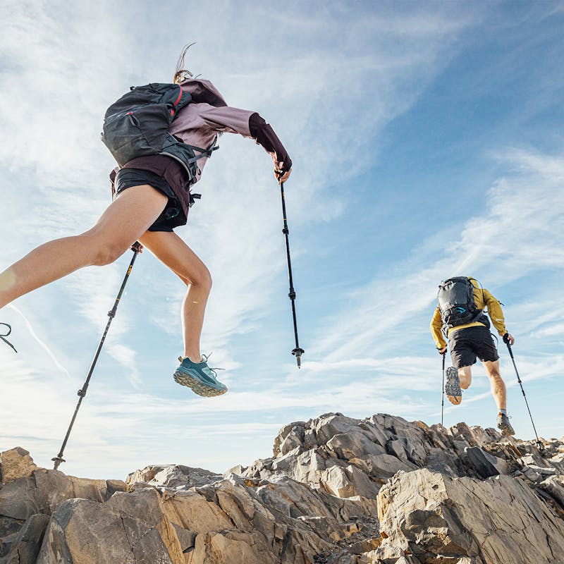 Two hikers scrambling across rocky terrain in the lightweight Oboz Katabatic low hiking shoes.
