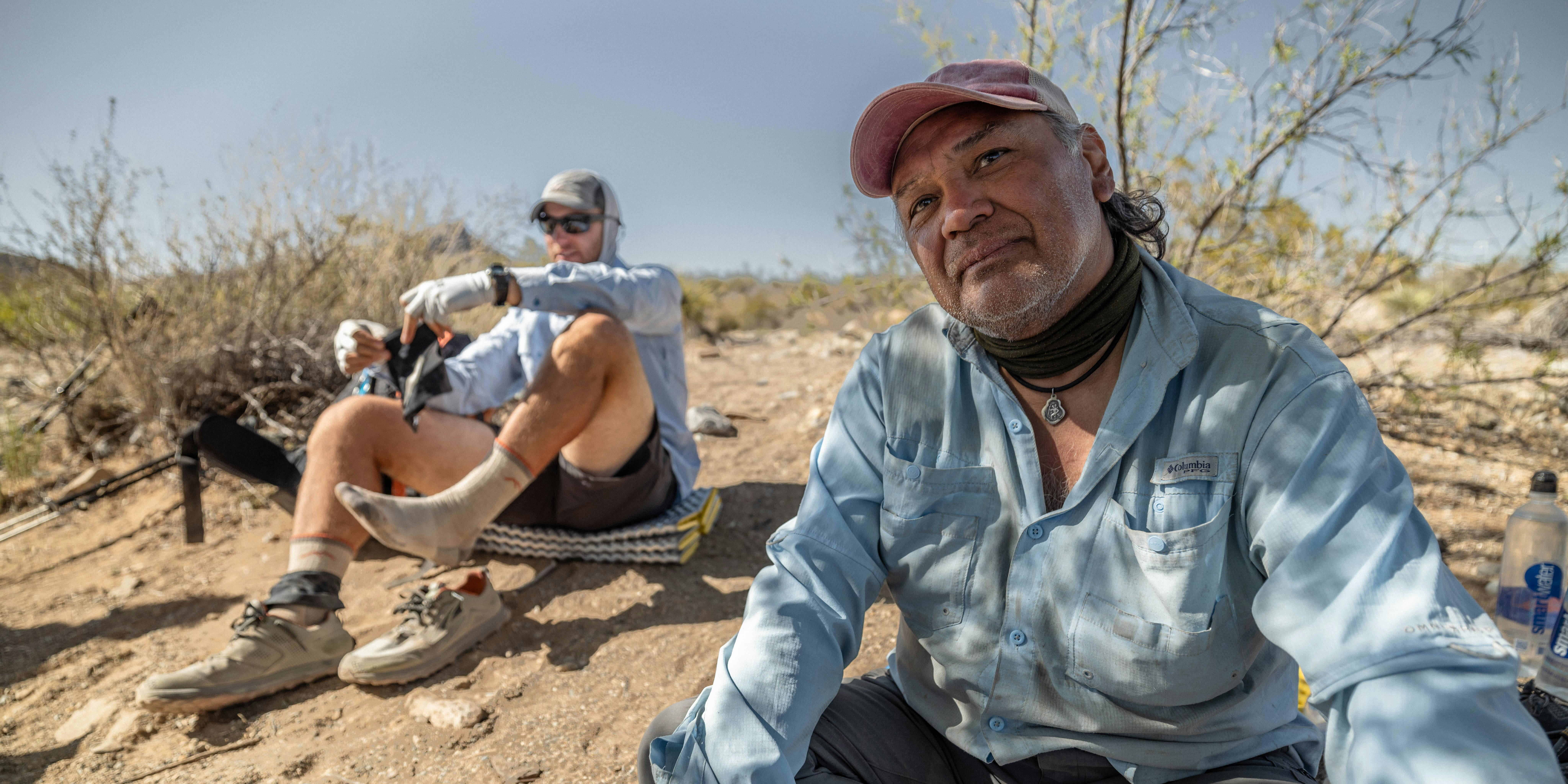 Two hikers taking a rest in the desert while hiking on the Continental Divide Trail.