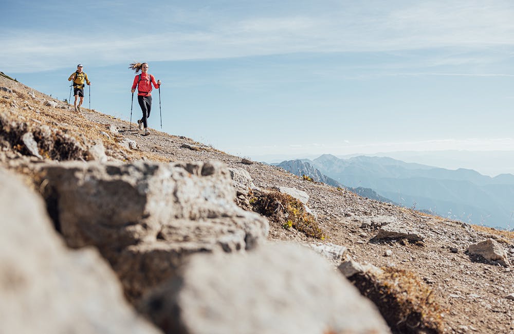 Two hikers descending a rocky trail in the Oboz Katabatic