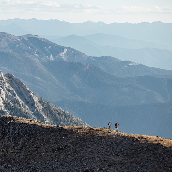 Two runners on ridgeline in the Bridger Mountain Range near Bozeman, MT.