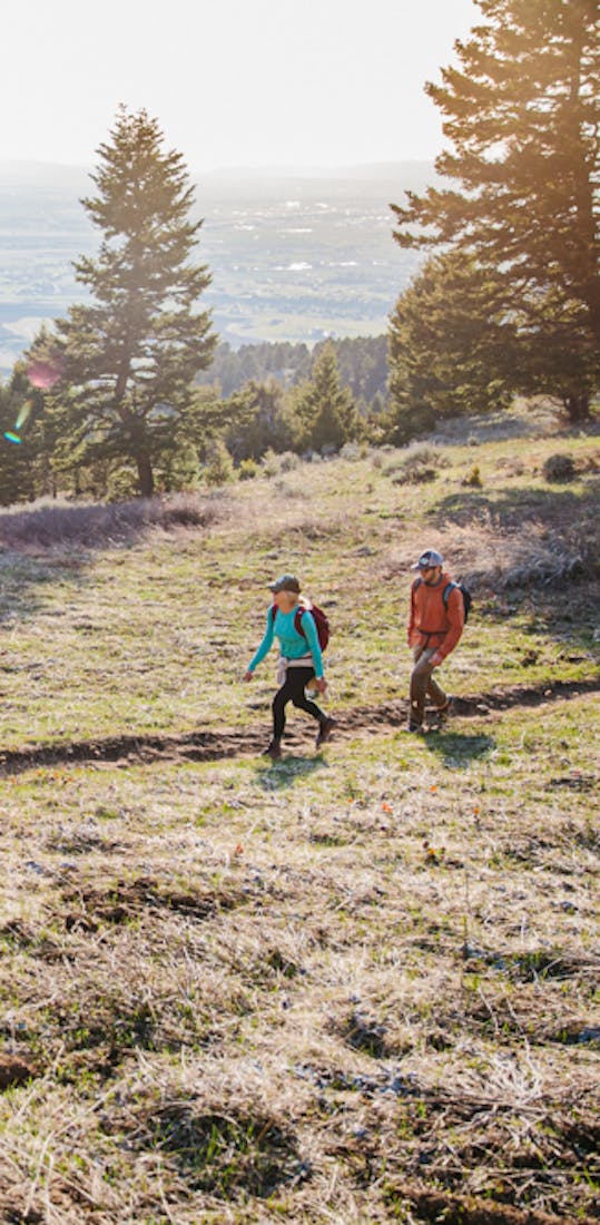 Two hikers on a trail wearing Oboz hiking shoes