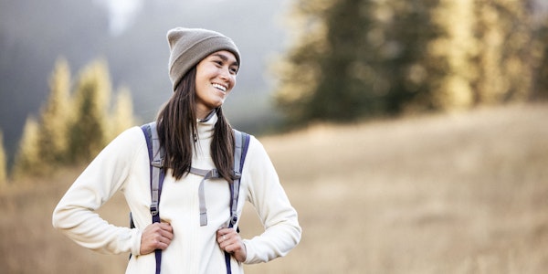 Women hiker smiling in nature with a backpack.