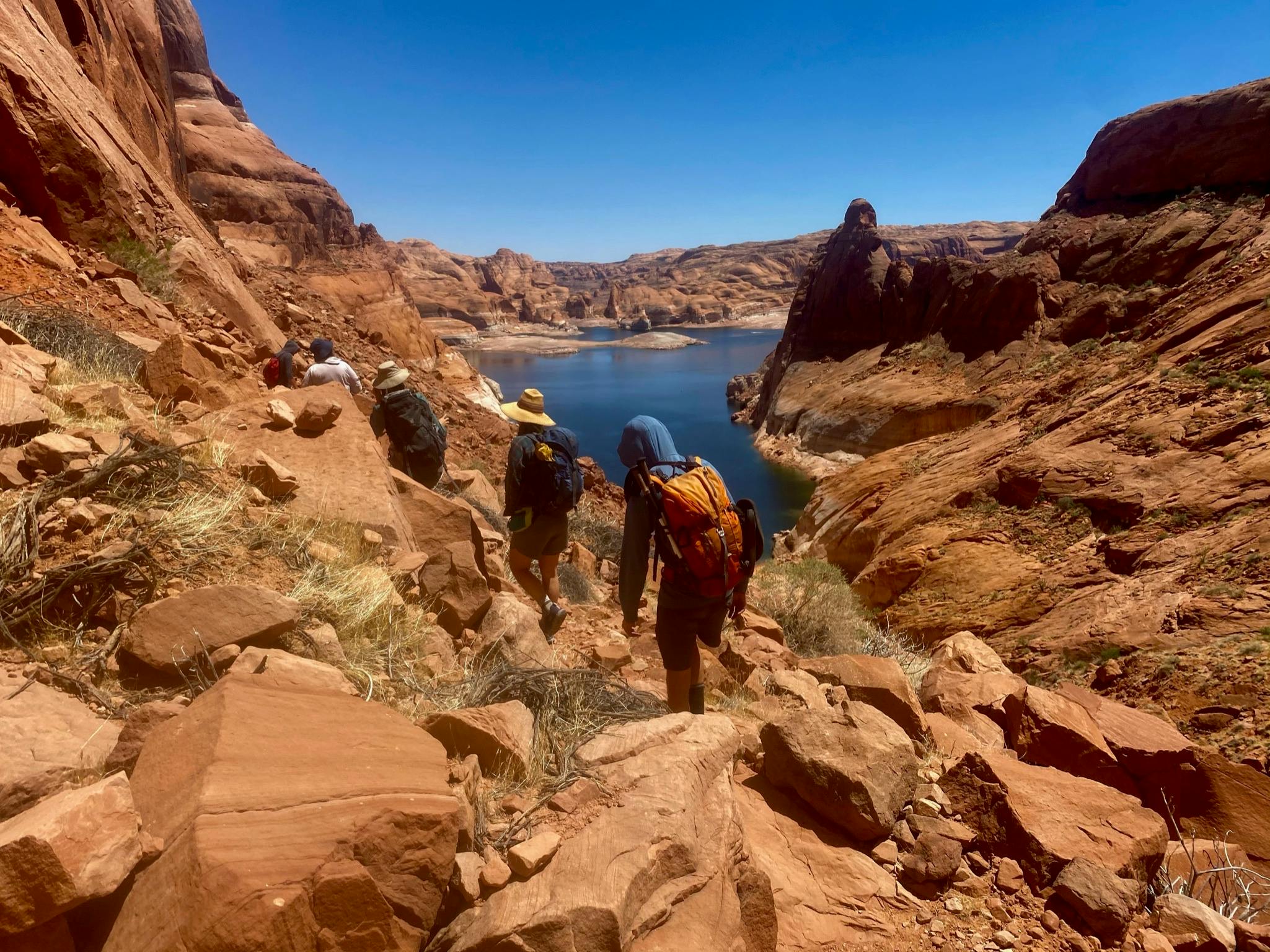 Joe St. Onge hiking to a desert lake on a blue sky day.