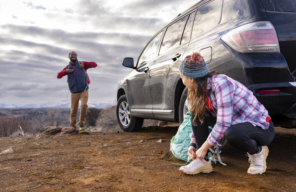 Two hikers at a trailhead wearing Oboz Katabatic Low hiking shoes.