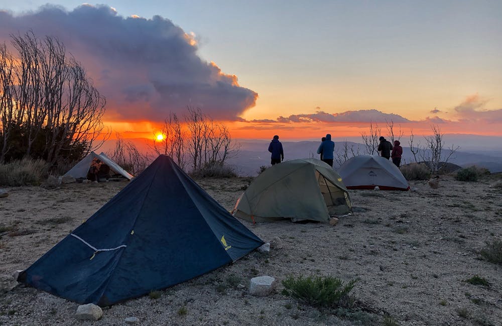 Ultralight tents set up on a ridgeline at sunset during summer