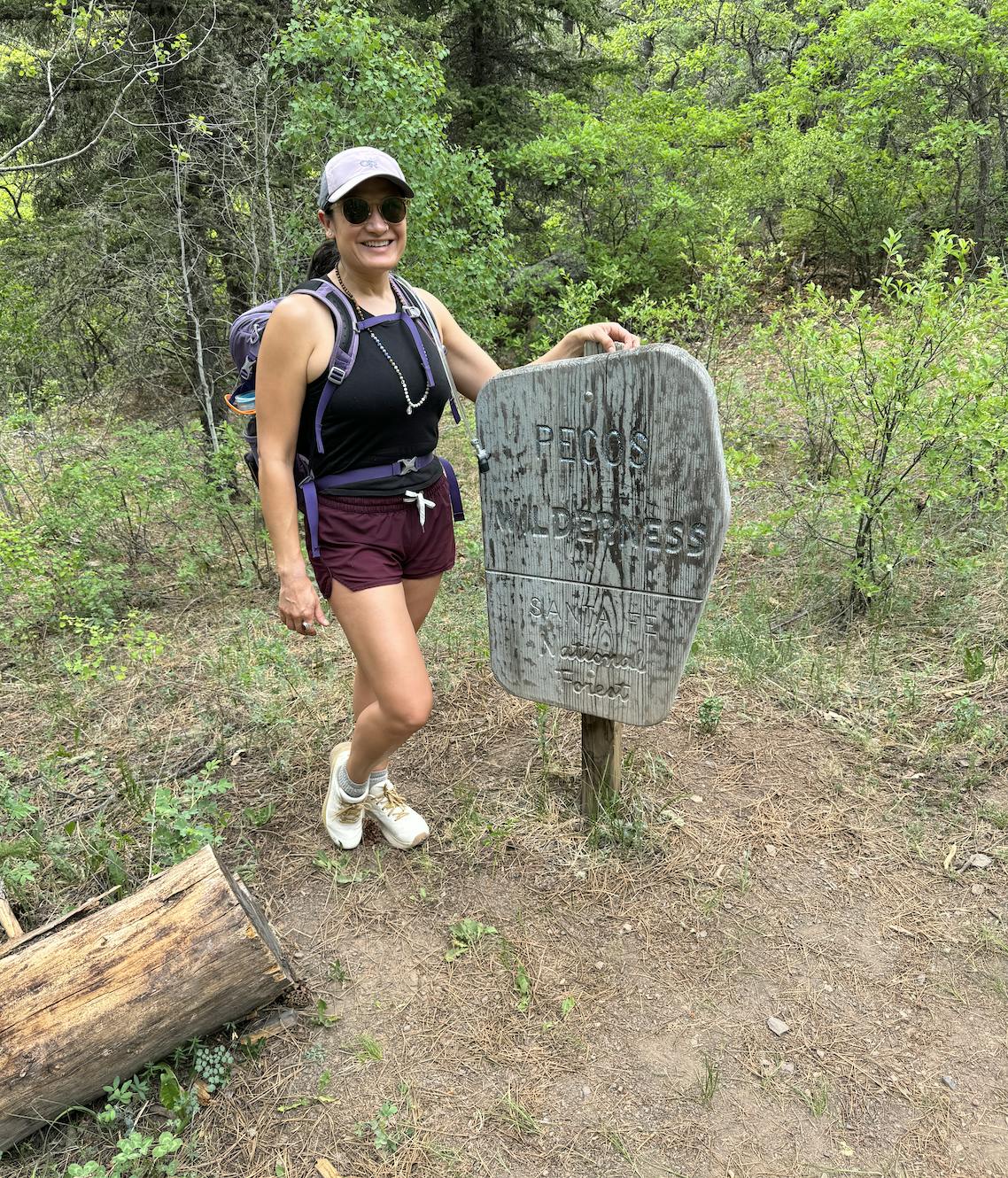 Karla Amador in her Oboz Katabatic Wind fast trail shoes at a trail sign. 