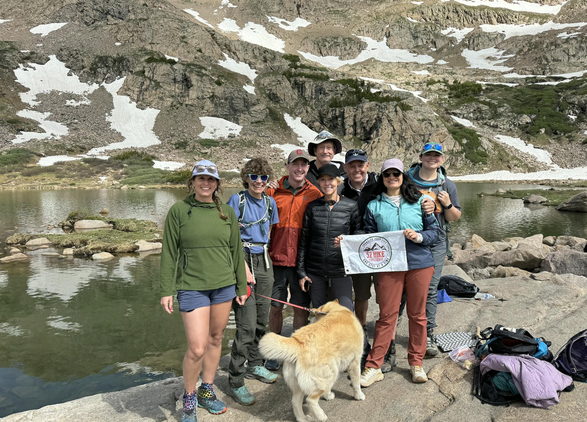 A group of 52 hikes challenge hikers at a mountain lake. 