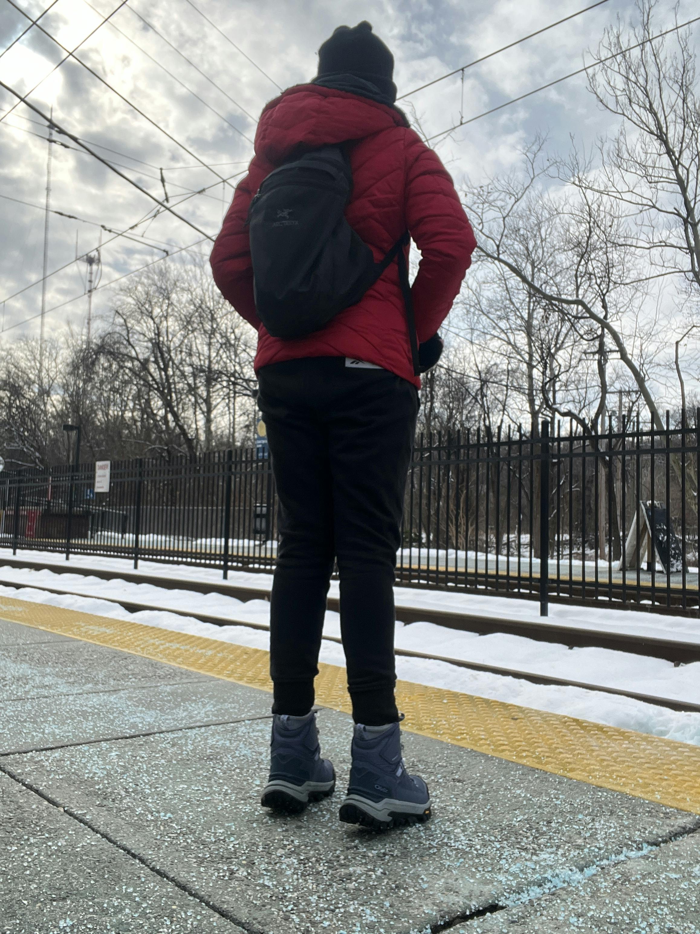 A hiker waits for the light rail in their Oboz Bangtail hiking shoe