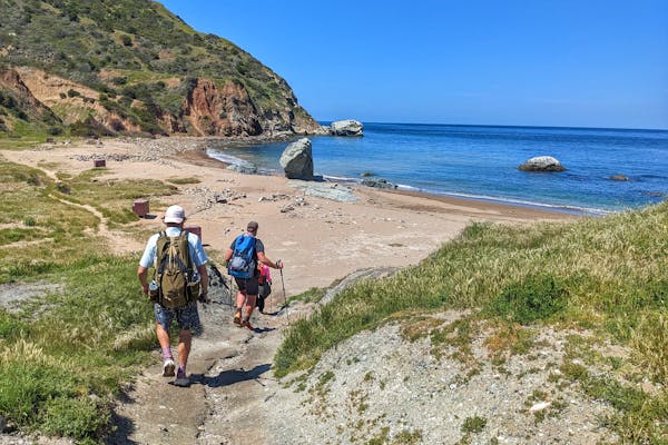 Hikers on the PCT in Oboz hiking shoes walk down to the beach