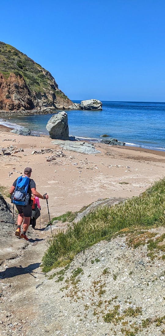 Hikers on the PCT in Oboz hiking shoes walk down to the beach