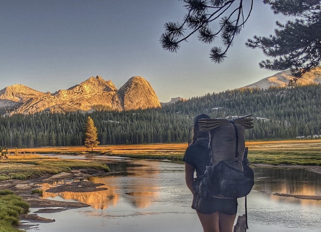 A hiker takes in a beautiful view during a thru-hike on the PCT