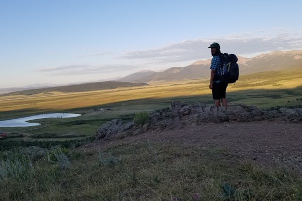 Tyler stands at an overlook during a backpacking adventure.