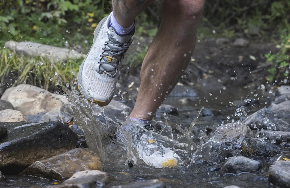 Hiker wearing Oboz Katabatic LT Gore-Tex hiking shoes through a stream.