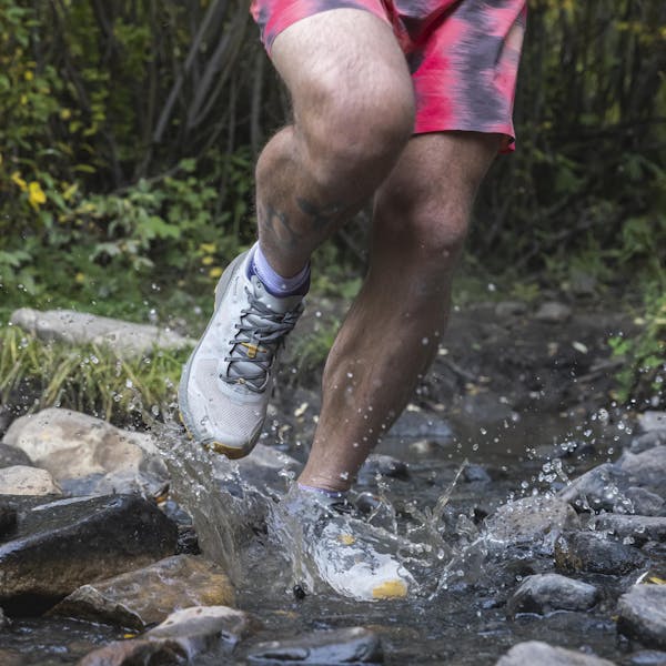 Hiker wearing Oboz Katabatic LT Gore-Tex hiking shoes through a stream.