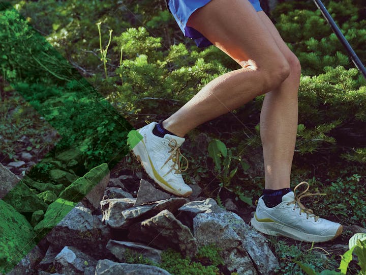 The new women's Oboz Katabatic Wind descending down a rocky trail in summer.