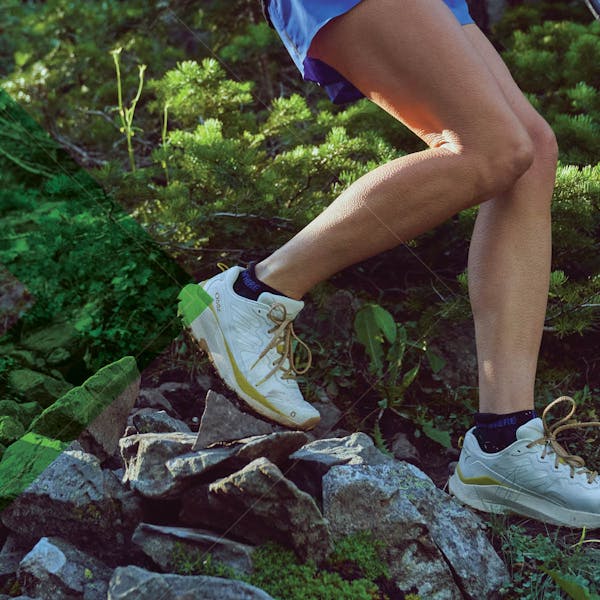 The new women's Oboz Katabatic Wind descending down a rocky trail in summer.