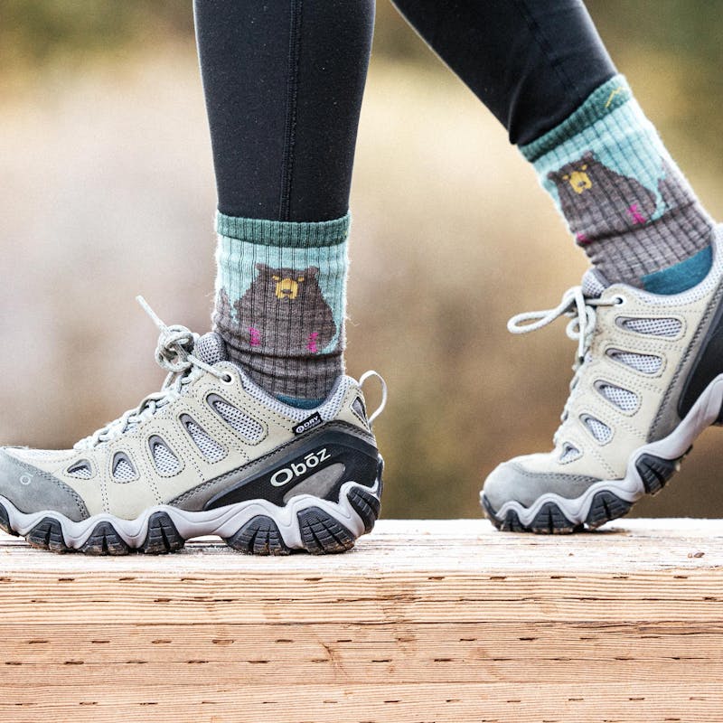 Woman walking on a wooden bridge in Oboz Sawtooth II boots