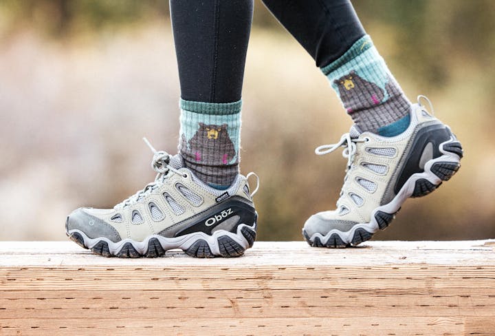 Woman walking on a wooden bridge in Oboz Sawtooth II boots