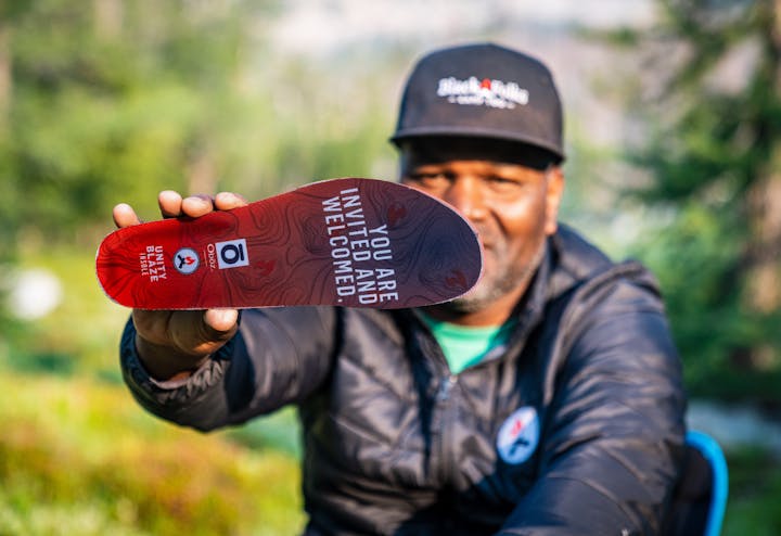 Earl Hunter holding an Oboz x BFCT Unity Blaze Trail insole.