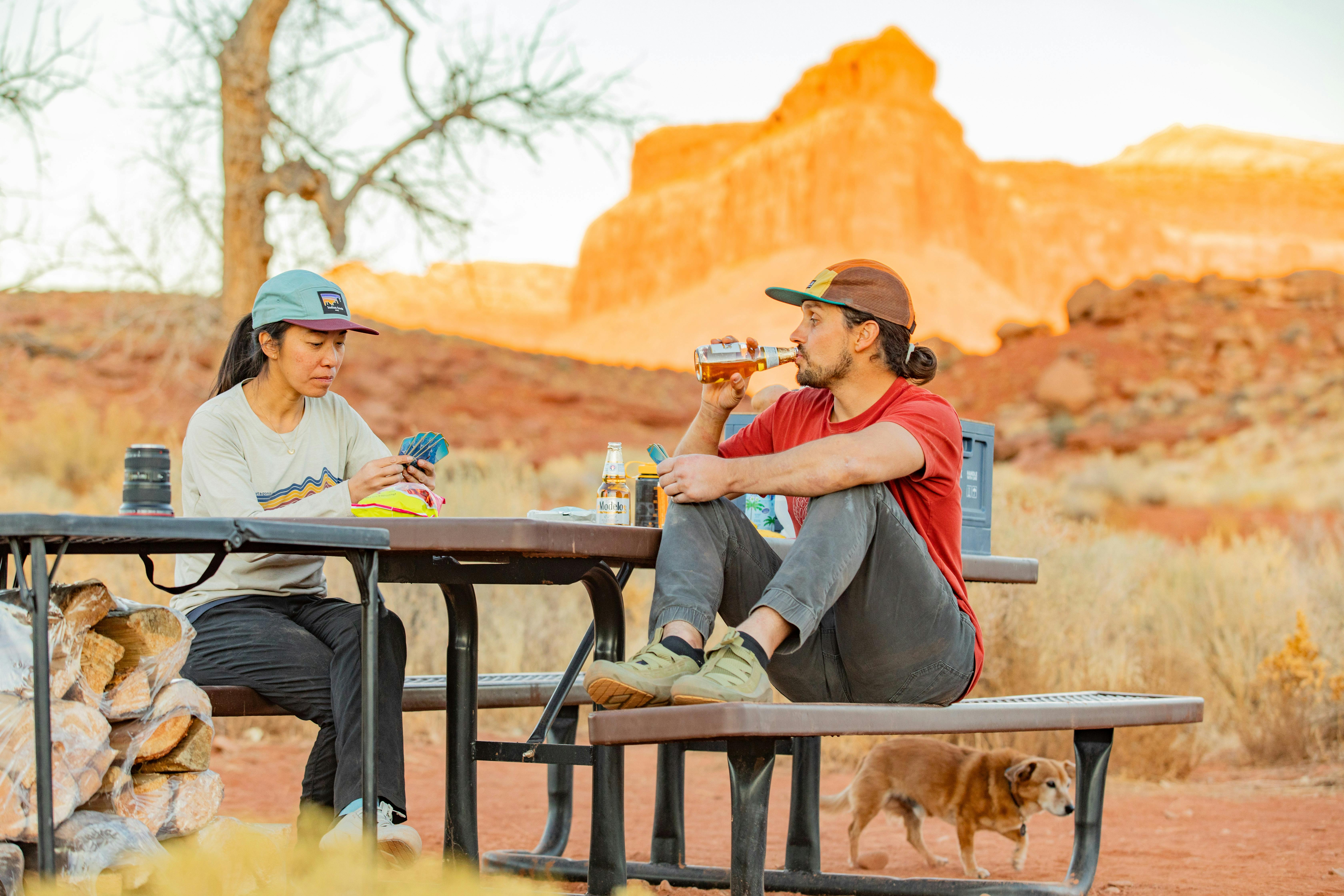 Two campers sit at at picnic table in their Oboz Whakata enjoying a meal.