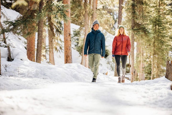 Two people stroll down a snowy path in Oboz winter boots.