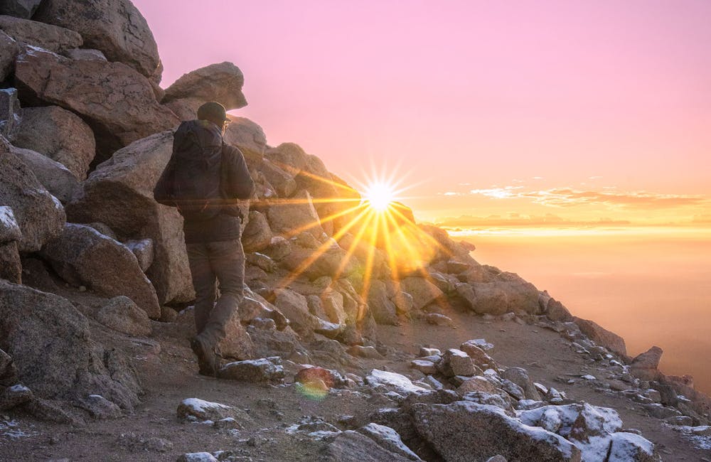 Oboz Footwear Trailblazer Evan Gill hiking with a beautiful sunset.