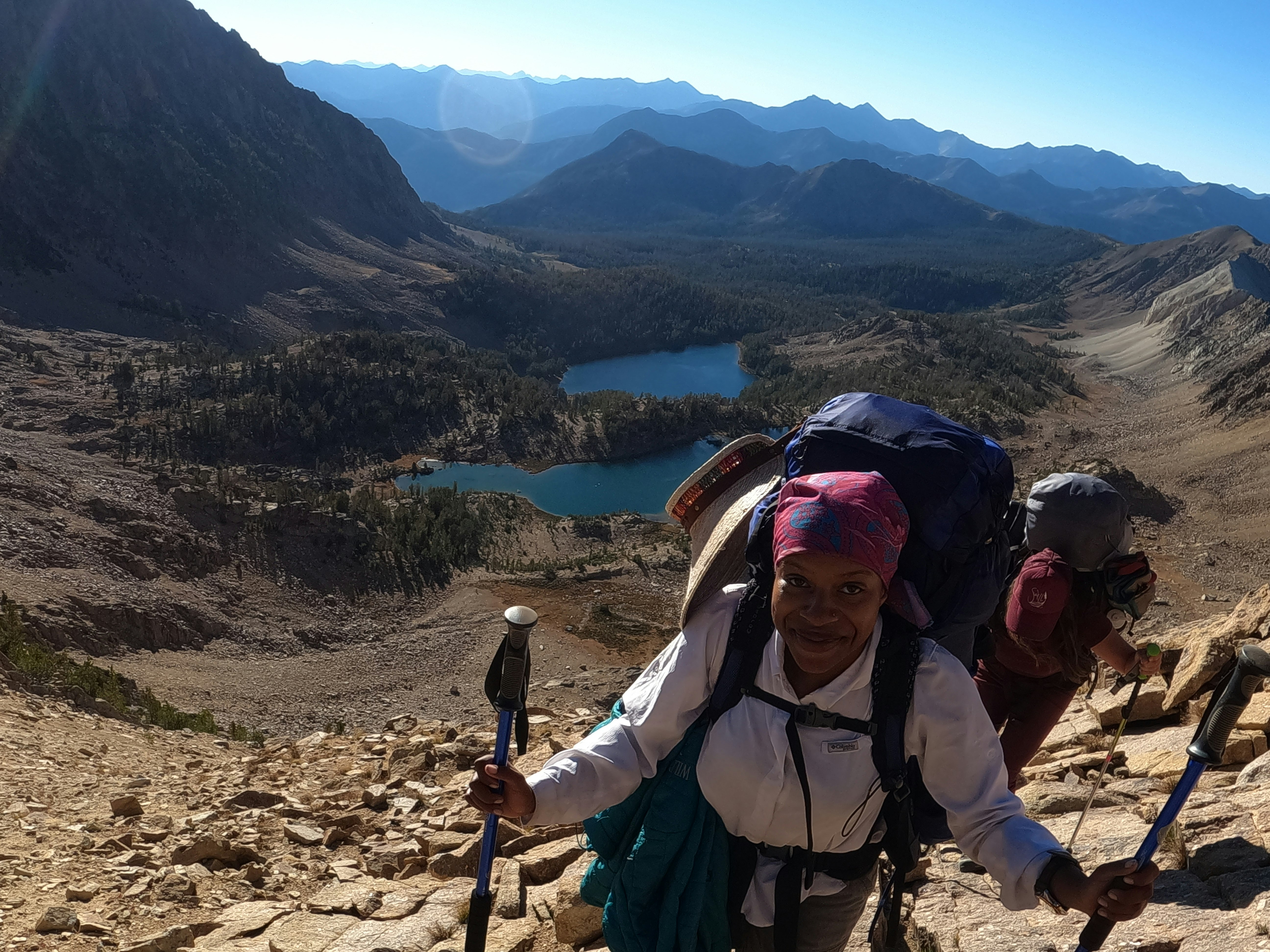 Diamon Clark backpacking with a companion on rocky scramble up a trail