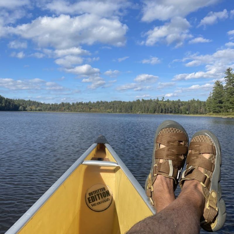 Person wearing Oboz Whakatā Trail Sandals in a canoe.