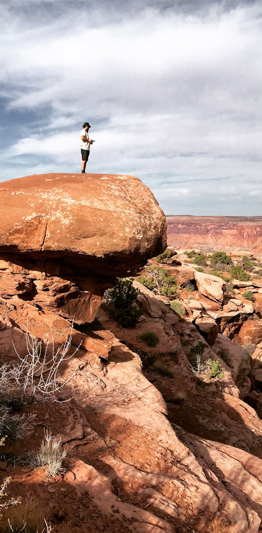 Alexi Kimiatek overlooking a river flowing through the canyon
