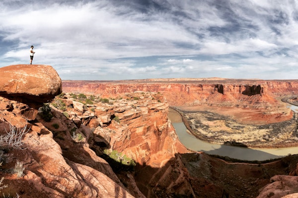 Alexi Kimiatek overlooking a river flowing through the canyon