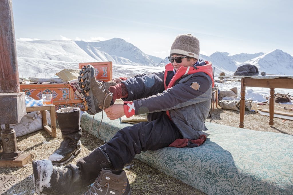 A hiker pulls on their Oboz Bridger hiking shoe