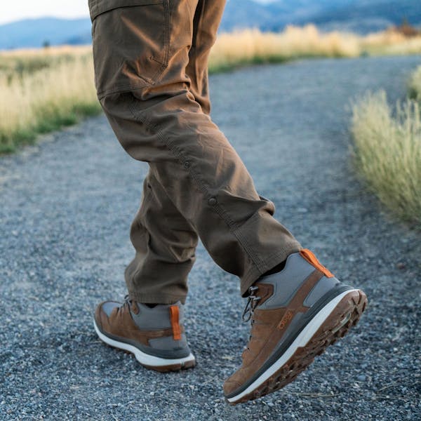 Man walking gravel path in Oboz Hyalite hiking shoes.