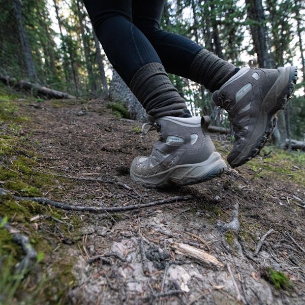 Hiking up a trail in the Oboz Sawtooth Ascent Mid hiking boots.