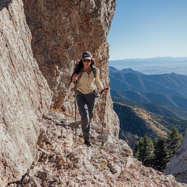 Woman climbing mountain ledge in Oboz Bridger Peak hiking boots.
