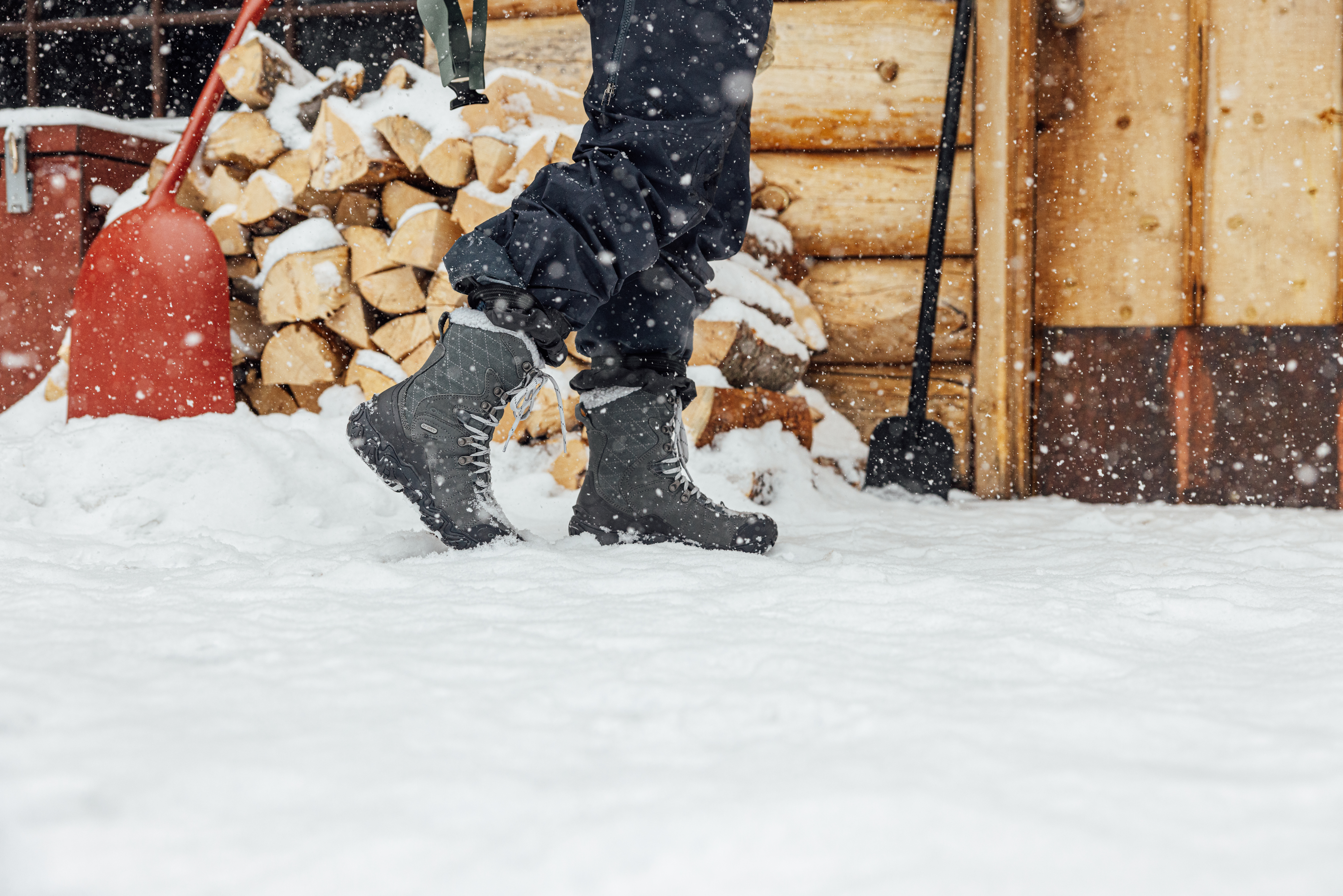 Woman walks to a cabin in Oboz Bridger snow boots.