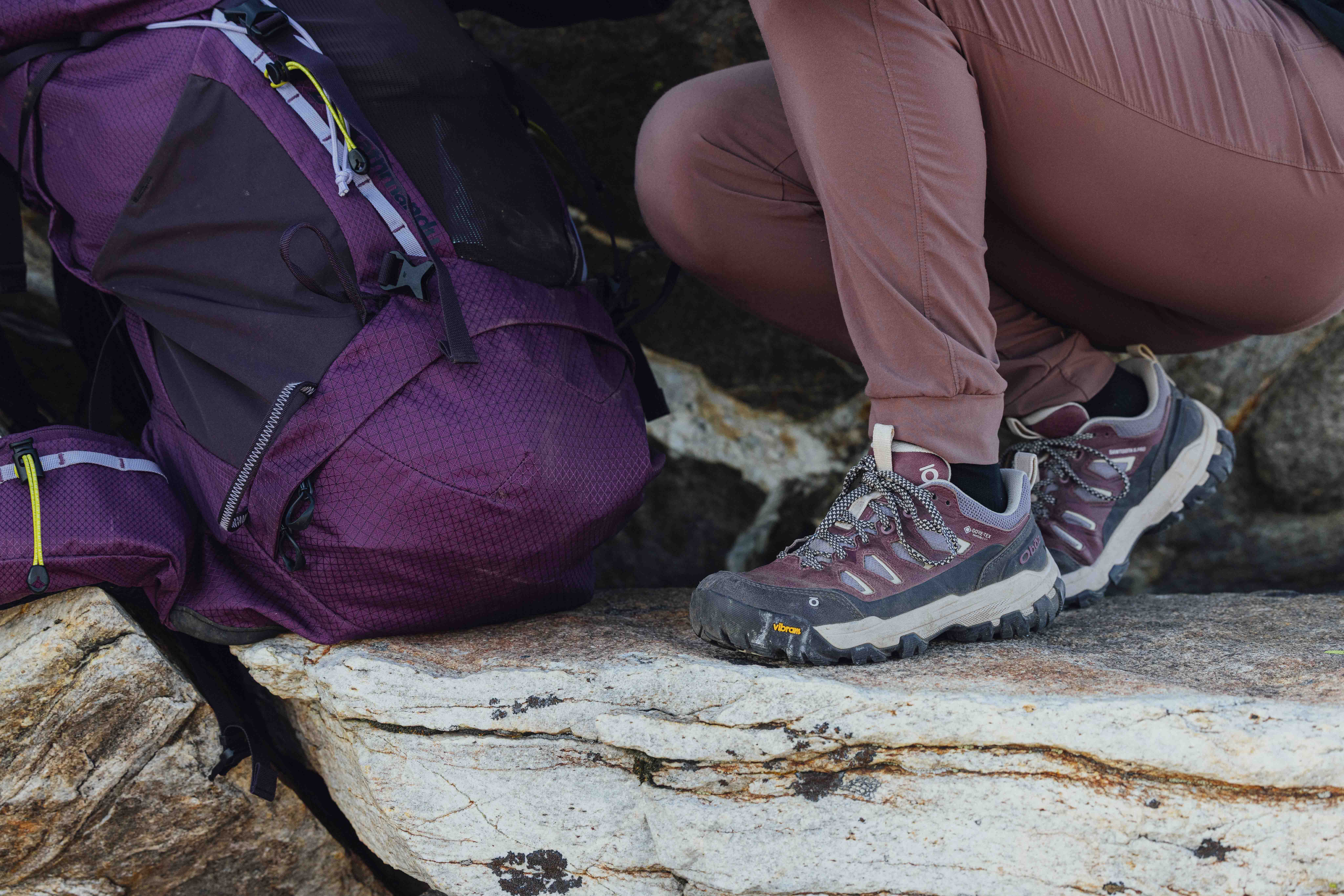 Oboz Sawtooth X PRO hiking boots on a rock with a backpacking backpack.