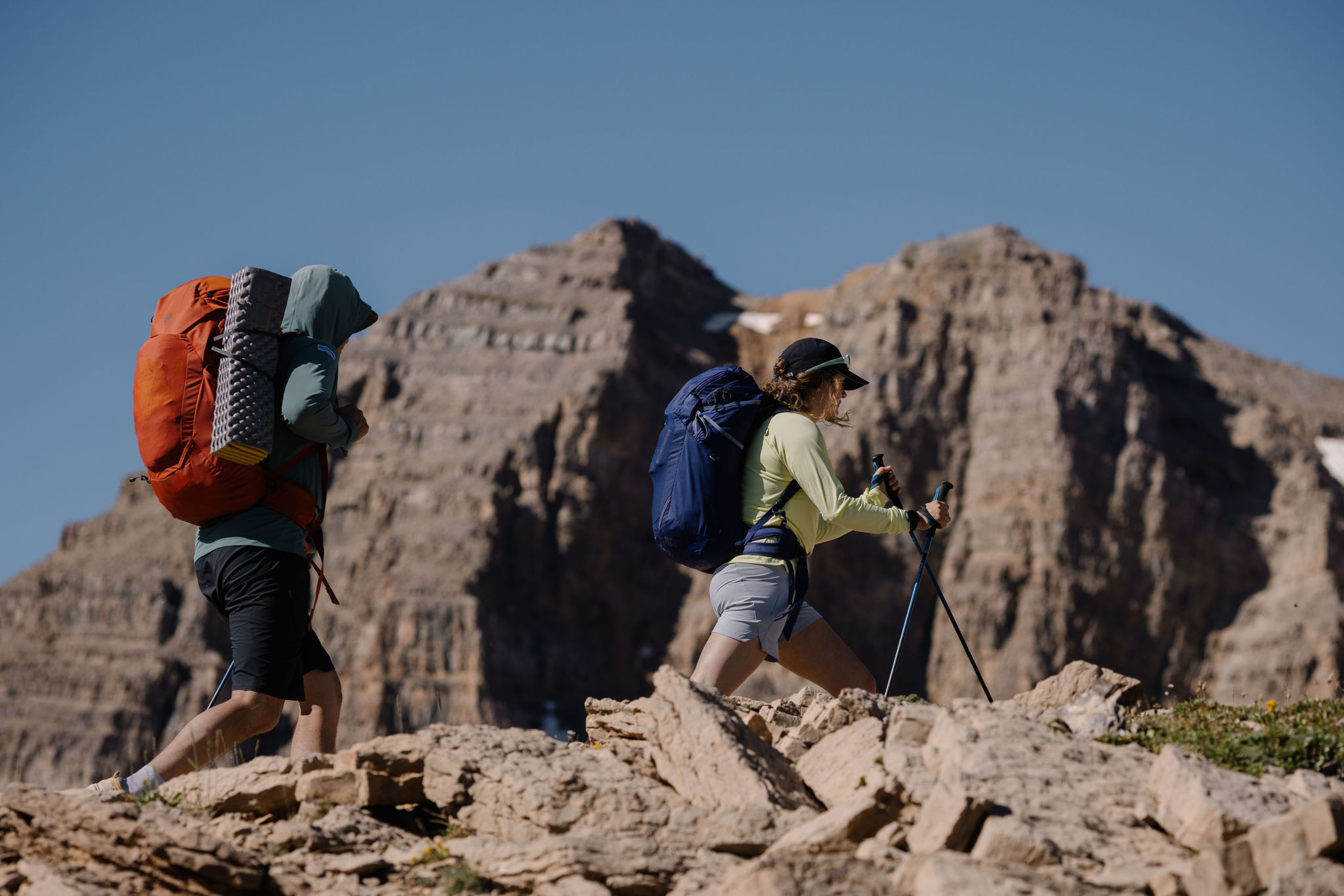 Two hikers wearing Oboz Katabatic RT hiking boots with backpacks on a rocky trail.