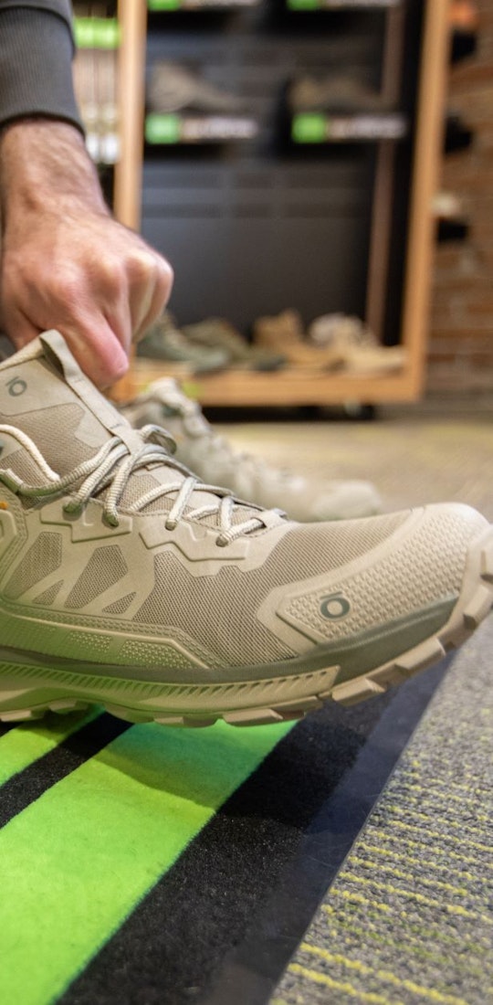 A person tries on an Oboz Katabatic Mid hiking shoe at a dealer. 