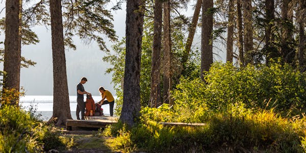 Two hikers packing their backpack while wearing Oboz hiking boots