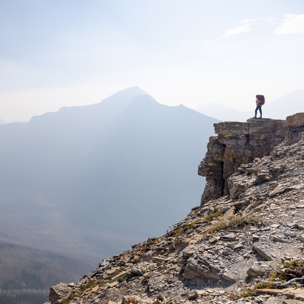 A hiker looking out into the beautiful, distant mountain landscapes. 