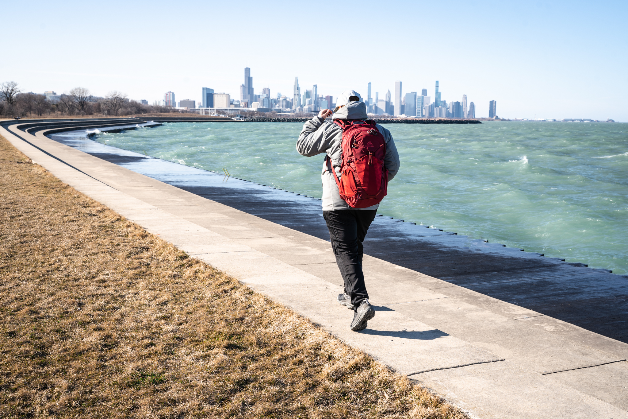 Urban adventurer hiking around in their Oboz hiking shoes on a city trail next to a blue body of water