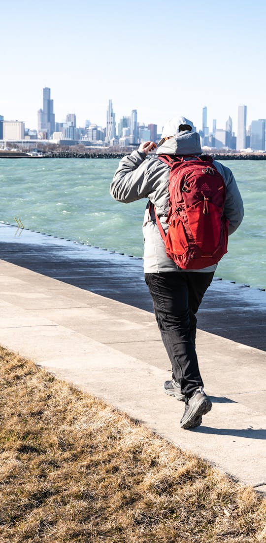 Urban adventurer hiking around in their Oboz hiking shoes on a city trail next to a blue body of water
