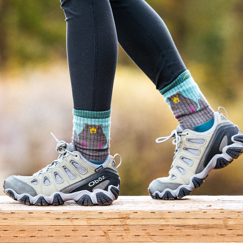 Woman walking on a wooden bridge in Oboz Sawtooth II boots
