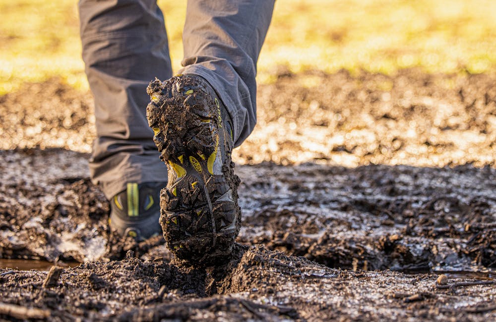 Mens sawtooth ii hiking boot going through a muddy trail