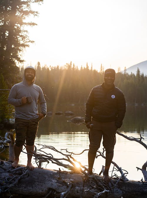 Earl Hunter Jr in nature wearing Black Folks Camp Too merchandise with a fellow hiker.