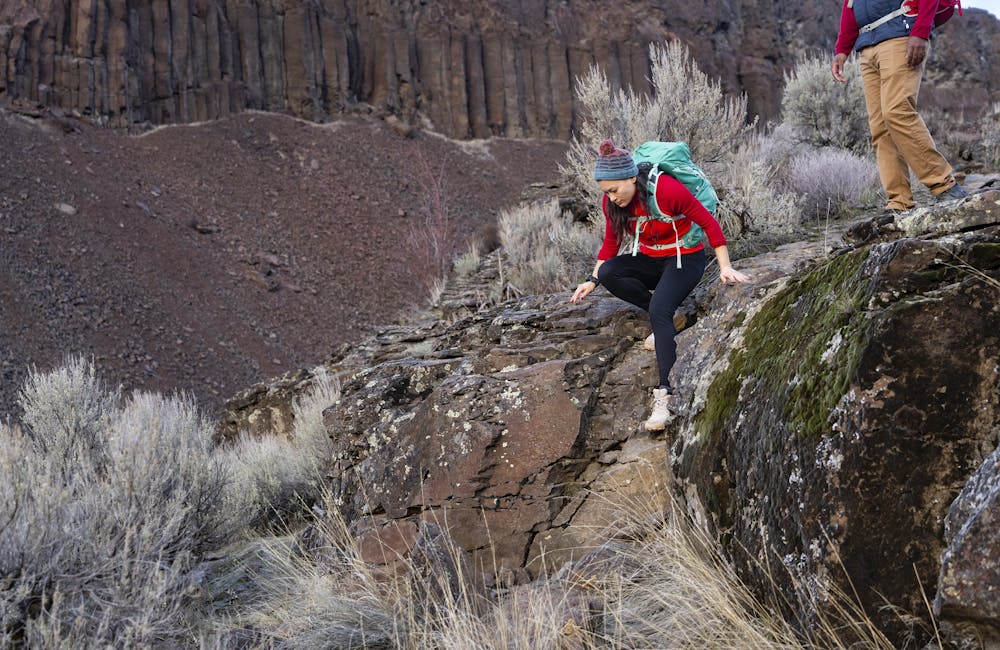 Hiker scrambling down some rocks in the Oboz Katabatic Low hiking shoe.
